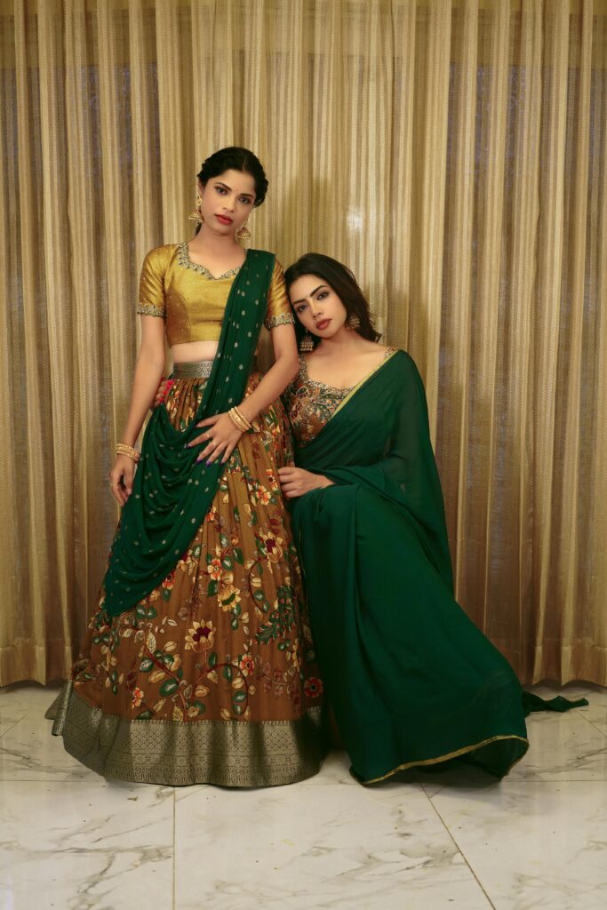 Beautiful portrait of two women in traditional Indian attire, showcasing cultural fashion.